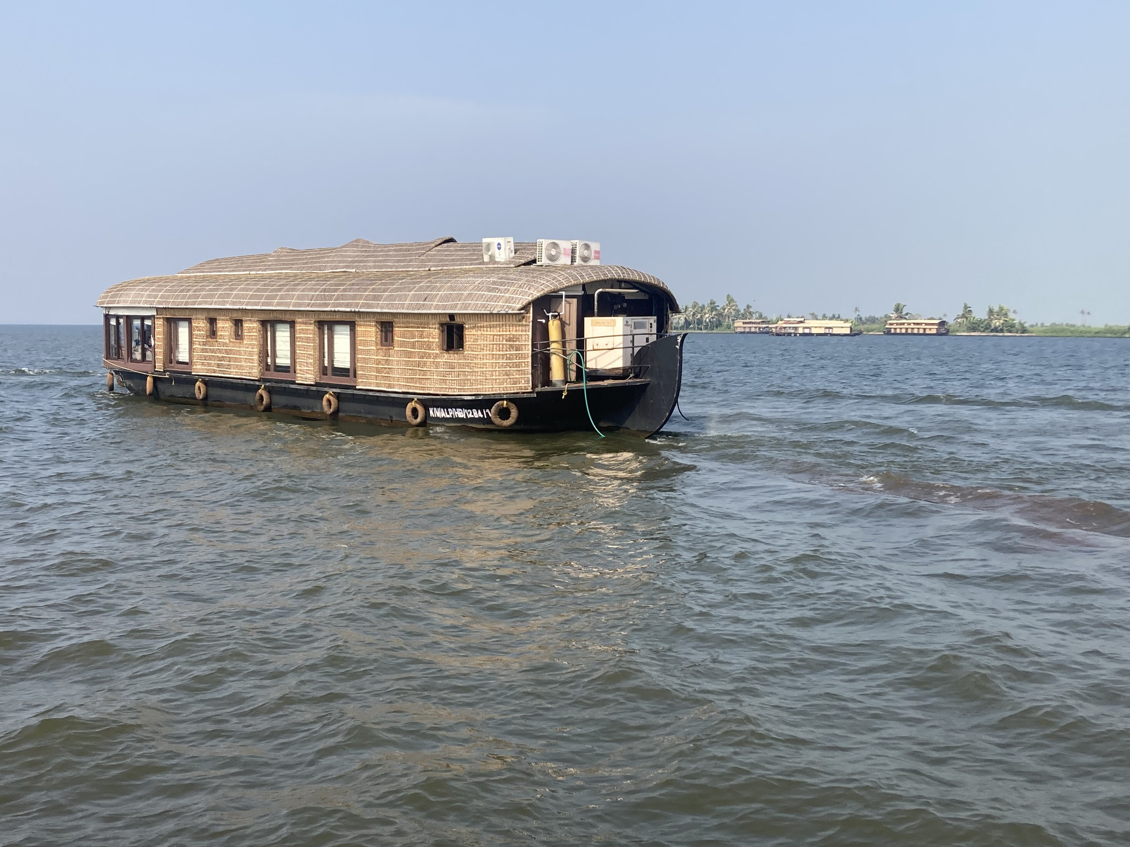 Backwater houseboat cruising through the palm-lined Alleppey backwaters in Kerala